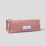 Pink pencil case with a gold zipper on a light gray background