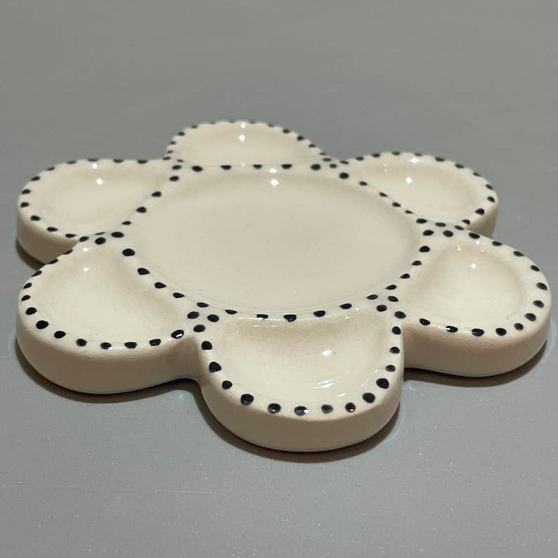 Ceramic paint palette with painted dot decoration around edge.
