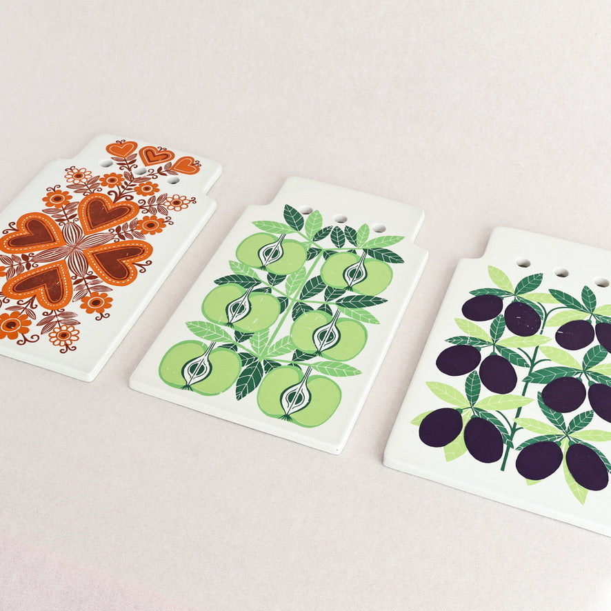 Three decorative cards with floral, fruit, and leaf designs on a light pink background.