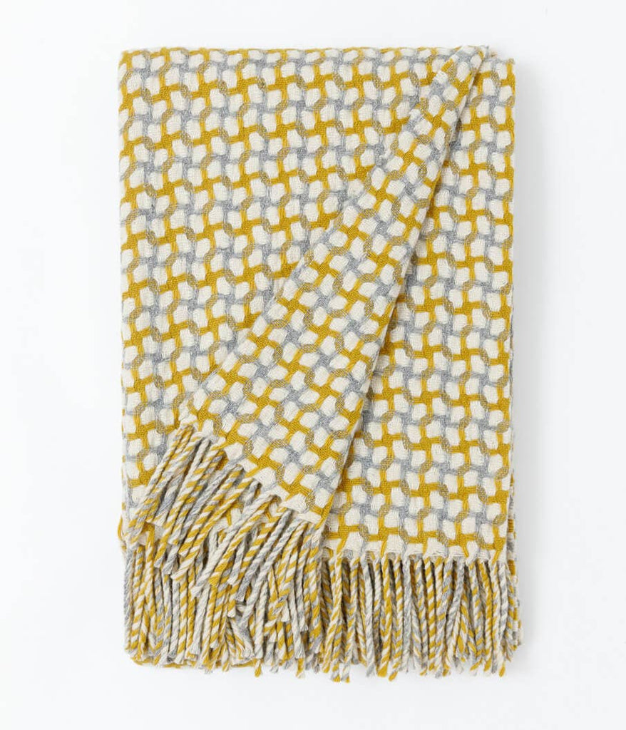 Yellow and gray patterned throw blanket with fringes on a white background