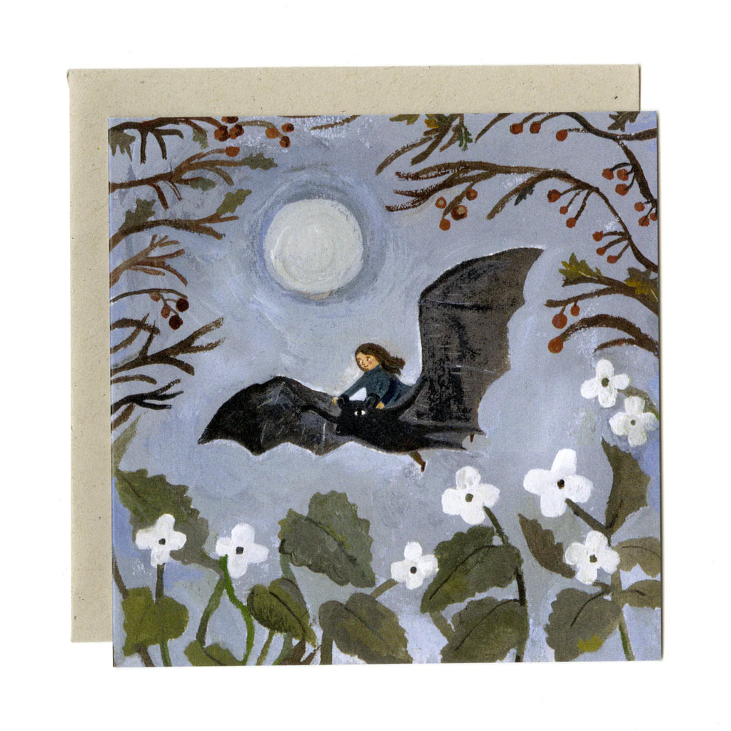 Greeting card with illustration of a girl riding a bat under a moonlit sky, surrounded by trees and flowers.