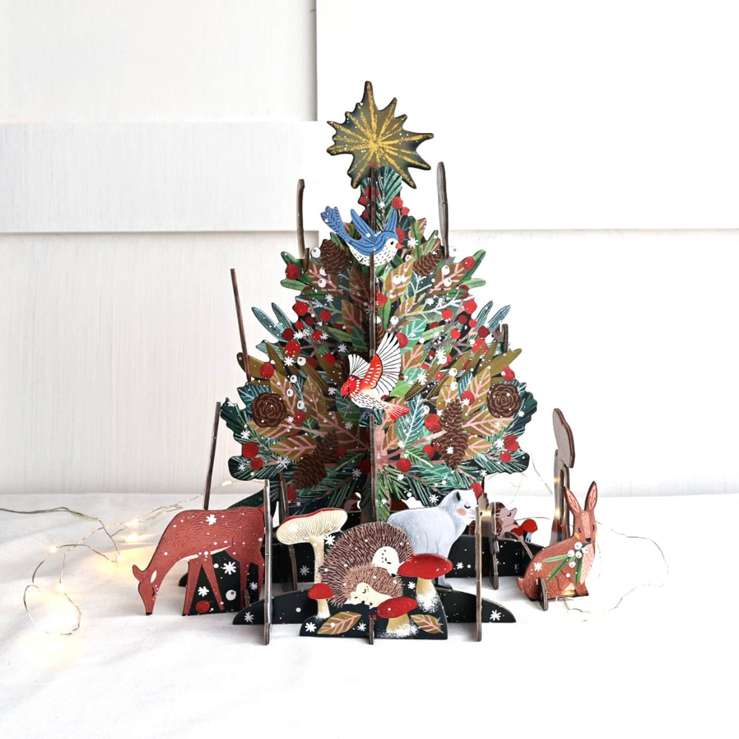 A festive pop and slot advent calendar featuring a Christmas tree with animals around it, made from sustainable card.