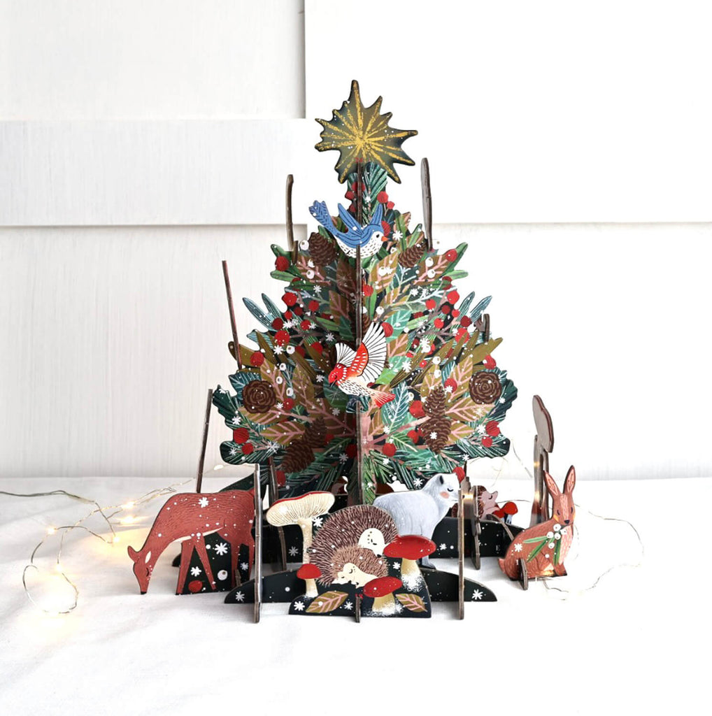 A festive pop and slot advent calendar featuring a Christmas tree with animals around it, made from sustainable card.