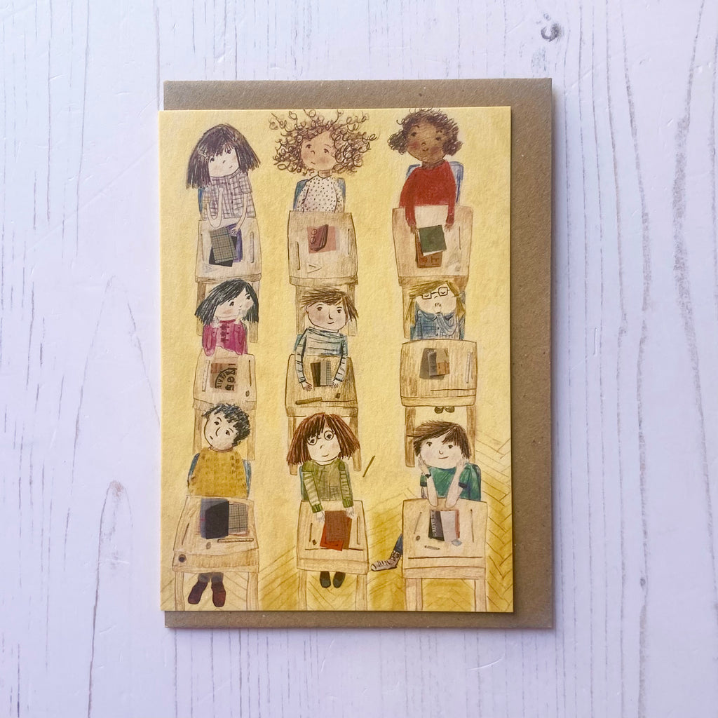 Card with illustrations of people stacked on top of each other, on a light wooden surface.