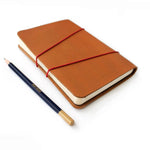 Brown leather notebook with a pen on a white background