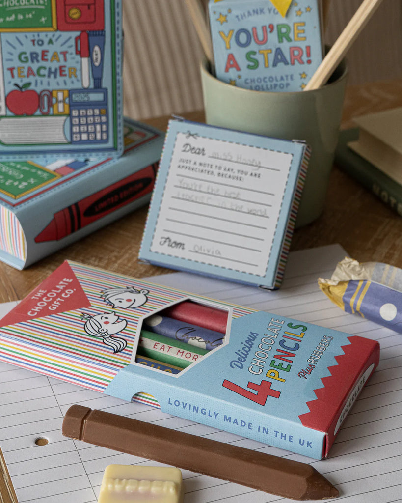 Pencil shaped chocolate and rubbers on a notebook