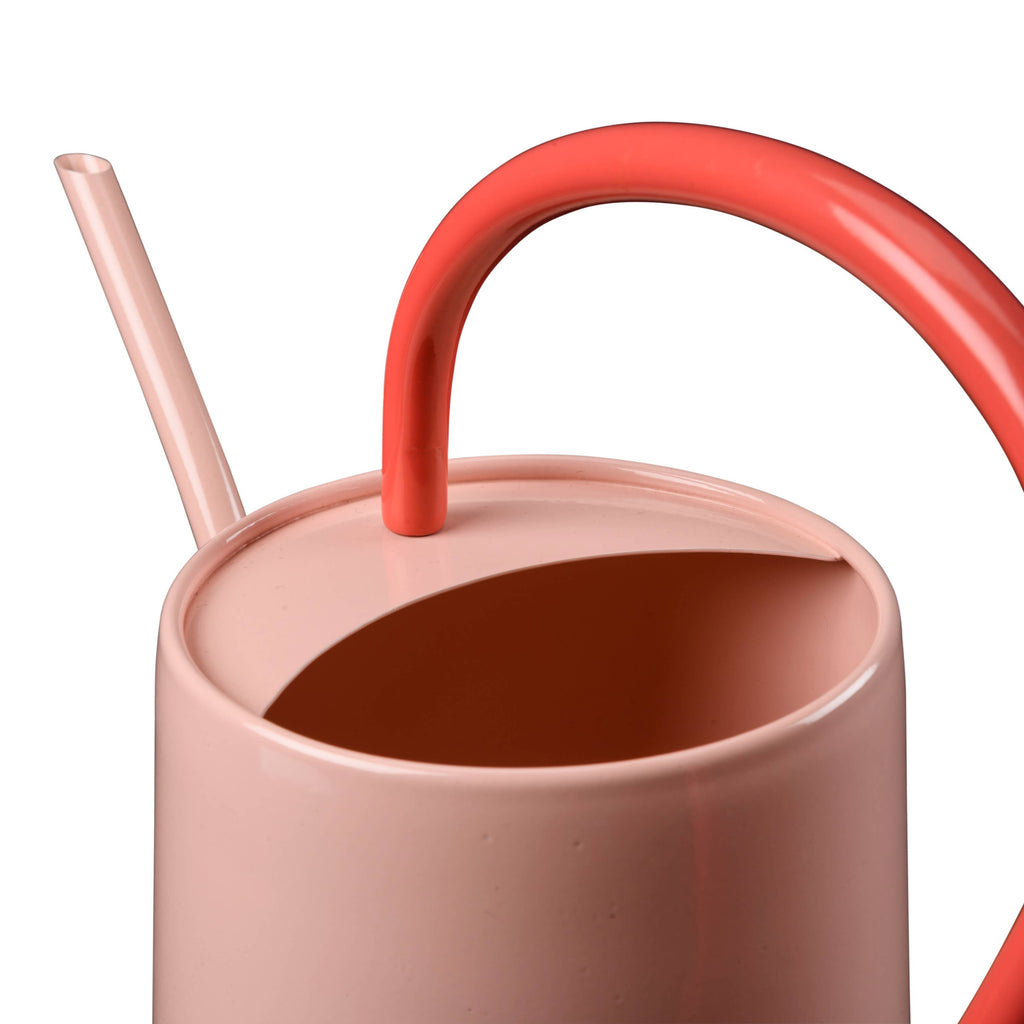 pink watering can close up with red handle
