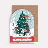 Christmas card with illustration of people decorating a tree, inside a snow globe, on a brown envelope.