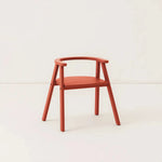 Red wooden kids chair, against a cream background
