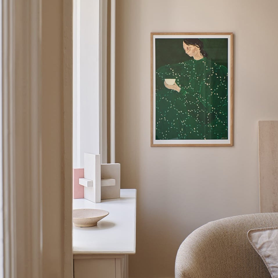 Art print of woman in green dress on living room wall